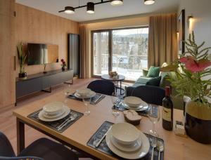 una sala da pranzo e un soggiorno con tavolo e sedie. di Trevilles Apartamenty - Stone Hill z basenem i SPA a Szklarska Poręba