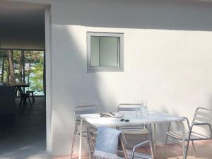Apartamentos Camping Coroso في ريبيرا: طاولة بيضاء مع كراسي ومرآة على الحائط