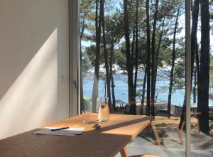 a wooden table in a room with a large window at Apartamentos Camping Coroso in Ribeira