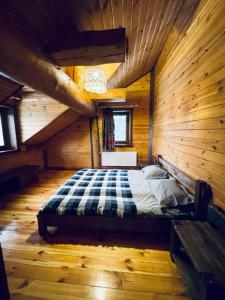 a bedroom with a bed in a wooden cabin at Lake House Стрижевка in Strizhevka