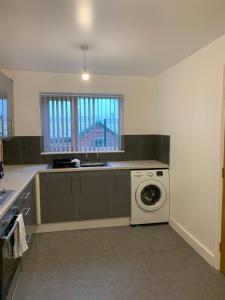 a kitchen with a washing machine and a sink at Campion Place in Sheffield