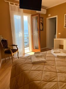 a bedroom with a large bed and a chair and a window at Villa Castello only room in Limone sul Garda