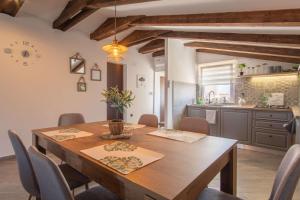 a kitchen and dining room with a wooden table and chairs at Opg Pelejš in Pag