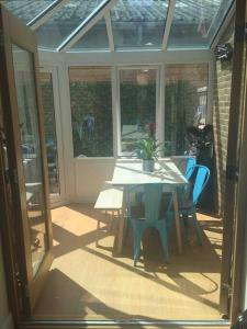 a screened in porch with a table and chairs at Twickes Townhouse in London