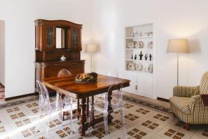 uma sala de jantar com uma mesa de madeira e cadeiras em Agapanthus em Matera