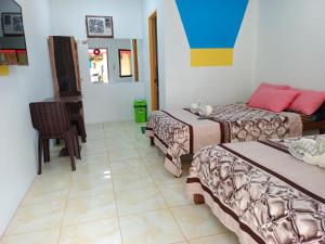 a room with two beds and a table and a chair at Hadefe Resort in El Nido