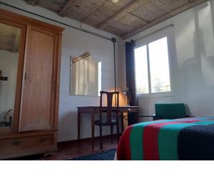 a bedroom with a bed and a desk and a mirror at La Bodega de Villa Bella in Espartinas
