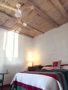 1 dormitorio con cama y techo de madera en La Bodega de Villa Bella, en Espartinas