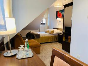 Sala de estar con cama y mesa con lámpara en Hotel Tadeusz, en Uszew