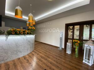 a lobby of a hotel with flowers on a counter at Hotel Tadeusz in Uszew