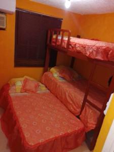 a bedroom with two bunk beds and a couch at Casa Reliance: equipada, palapa privada y alberca in La Sabana