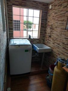 a small bathroom with a sink and a washing machine at Casa Reliance: equipada, palapa privada y alberca in La Sabana