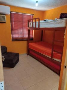 a bedroom with two bunk beds and a window at Casa Reliance: equipada, palapa privada y alberca in La Sabana