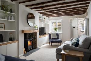 een woonkamer met een open haard en een televisie bij The Cottage in Cirencester