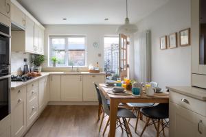een keuken met een houten tafel en stoelen en een tafel en een tafel bij The Cottage in Cirencester