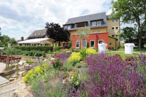 a garden with purple flowers in front of a house at Berggasthof Banzer Wald in Bad Staffelstein