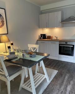 eine Küche mit einem Tisch und Stühlen in einer Küche in der Unterkunft Friesen-Lodge Ferienwohnungen in Breklum