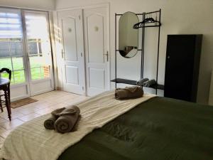 a bedroom with a large bed with towels on it at Chambre & Caux in Thiergeville