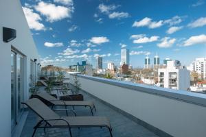 a balcony with chairs and a view of the city at Regency Way Montevideo Hotel in Montevideo