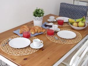 - une table avec des assiettes blanches et des croissants dans l'établissement La torretta 13 - appartamento vista mare, à Formia