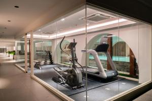 een kamer met een fitnessruimte met een loopband en spiegels bij Away Bangkok Riverside Kene in Bangkok