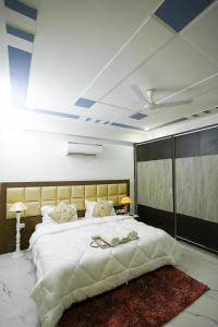 a bedroom with a large bed with two shoes on it at Lime Tree Service Apartment - Near Artemis Hospital ,Gurgaon in Gurgaon