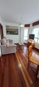 ein Wohnzimmer mit einem Sofa und einem Tisch in der Unterkunft Apartamentos Tesón Ribadeo in Ribadeo