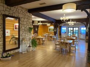 a restaurant with tables and chairs and a stone wall at Hotel Tadeusz in Uszew