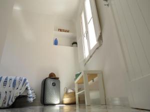 - une chambre avec des murs blancs, une fenêtre et une valise dans l'établissement La torretta 13 - appartamento vista mare, à Formia