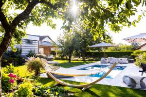 een tuin met een hangmat en een zwembad bij 110qm Countryside Loft in Neufahrn in Niederbayern