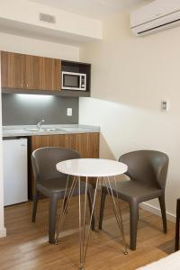 a kitchen with two chairs and a white table at Regency Way Montevideo Hotel in Montevideo