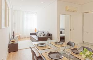 ein Wohnzimmer mit einem Tisch, Stühlen und einem Sofa in der Unterkunft Luxury Prime Batalha Apartments in Porto