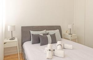 ein weißes Schlafzimmer mit einem Bett mit zwei Nachttischen in der Unterkunft Luxury Prime Batalha Apartments in Porto