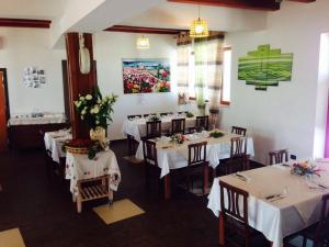 a restaurant with white tables and chairs with flowers on them at Agriturismo La Ferrovia in Molfetta