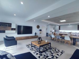 a living room with a tv and a table and chairs at Elegante y moderna Villa Miami in Adeje +131 photos