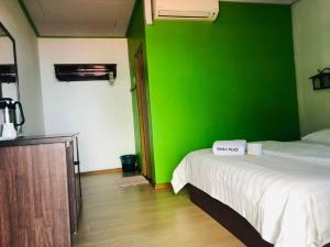 a green wall in a room with a bed at Suhaila Palace in Perhentian Island