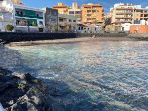 un bacino d’acqua con spiaggia e edifici di La Brisa del Mar - Piscina y Terraza a Puertito de Güímar