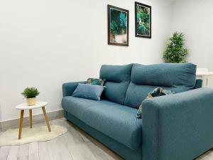 niebieską kanapę w salonie ze stołem w obiekcie Apartamento Centro San Diego w mieście Sanlúcar de Barrameda +18 zdjęć