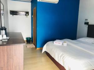 a room with a bed and a blue wall at Suhaila Palace in Perhentian Islands