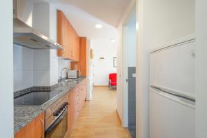 a kitchen with a white refrigerator and wooden cabinets at Vipimmoble ! in Guardiola de Berguedà