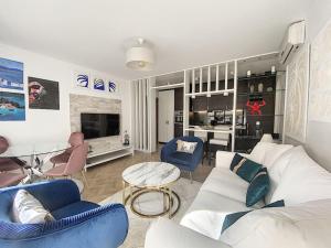 ein Wohnzimmer mit einem weißen Sofa und blauen Stühlen in der Unterkunft Appartement style architecte proche de la plage in Cannes