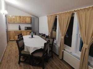 a dining room with a table and chairs and a kitchen at Casa Anghel in Bilbor