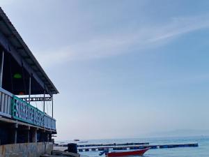 a building next to the ocean with boats in the water at Suhaila Palace in Perhentian Islands