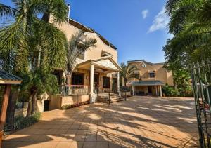 a large house with palm trees in front of it at Meritas Crystal Resort in Lonavala