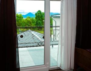 una puerta corredera de cristal con vistas a un balcón en Guesthouse Pink Panther, en Udbina