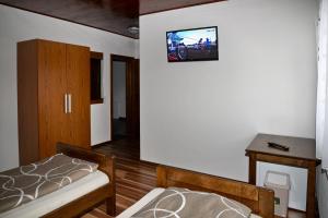 a bedroom with a bed and a tv on the wall at Guesthouse Pink Panther in Udbina