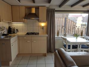 a kitchen and dining room with a table and a kitchen and a kitchen at TINY HOUSE MIMI Bed by the Sea - Adults only in Zoutelande