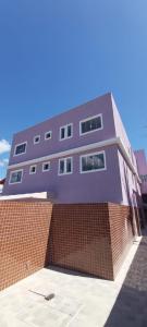 a purple building on top of a brick wall at Apartamento Ponta da Fruta para até 4 pessoas 201 in Vila Velha