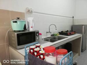 una pequeña cocina con fregadero y microondas en D'Haja 32 KLIA SEPANG with 2 Airconds & FREE WiFi, en Banting