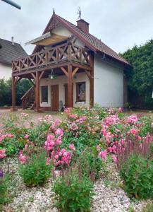 a garden with pink flowers in front of a house at Apartament z tarasem in Stegna